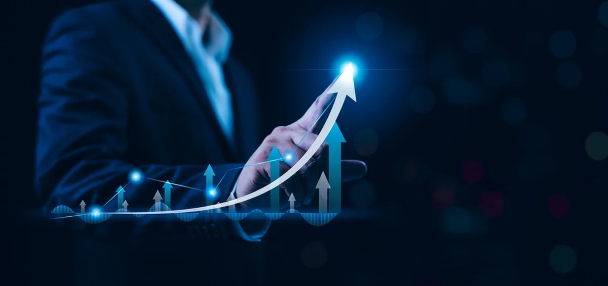 Businessman pushing bar graph higher with finger.