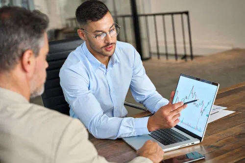 A financial advisor explaining a chart on a tablet.