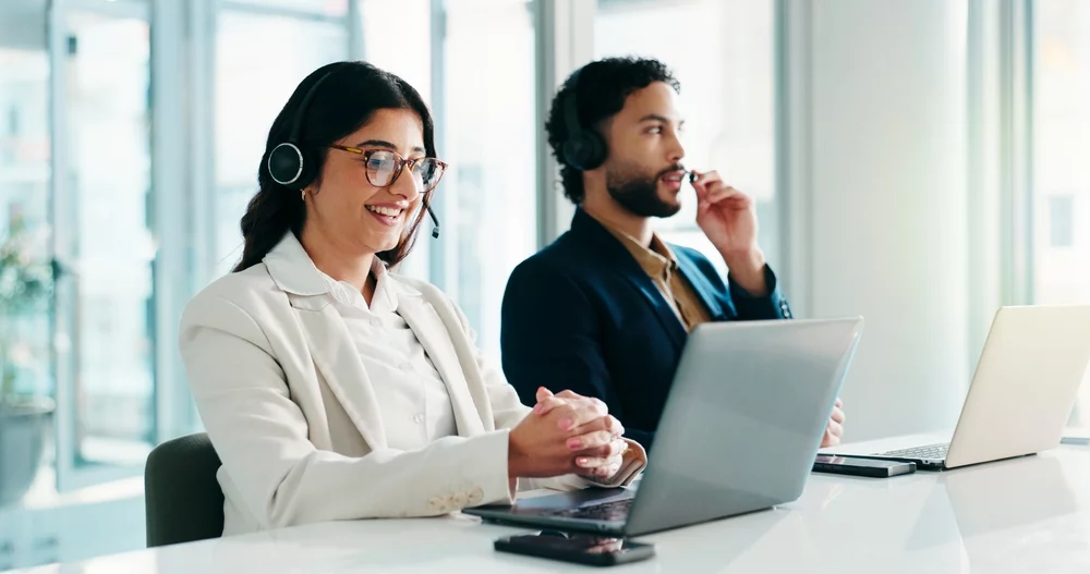 Woman and men at desk speaking to clients remotely