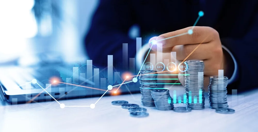 A visualization of investments growing, with a line chart rising over a stack of coins.