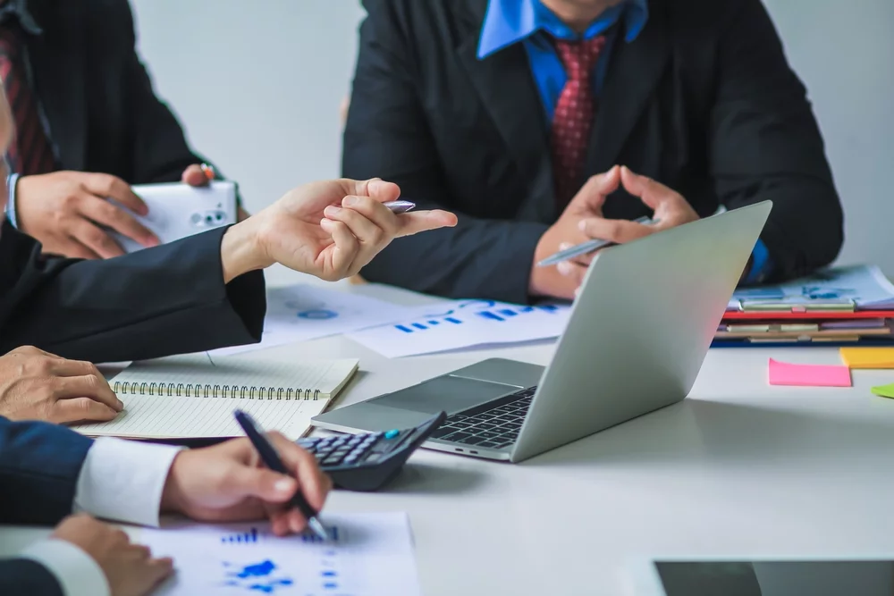 A close-up photo of a firm’s advisory board gathered around a laptop.